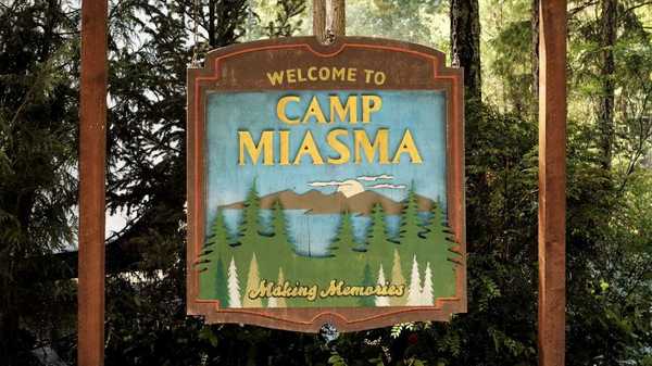 A close-up of the camp sign in Teenage Sex and Death at Camp Miasma
