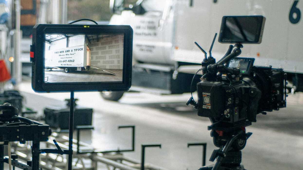 A commercial shoot with a camera pointed at a moving truck visible on the monitor