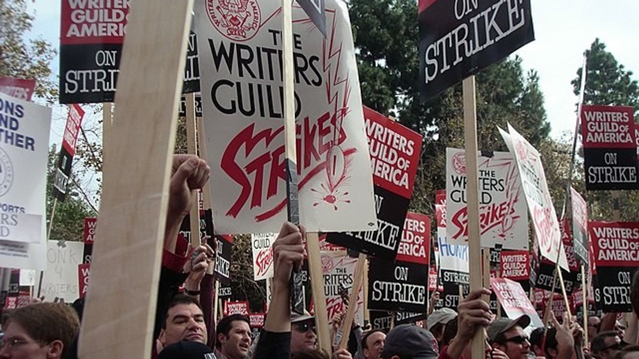 A crowd of people holding strike signs
