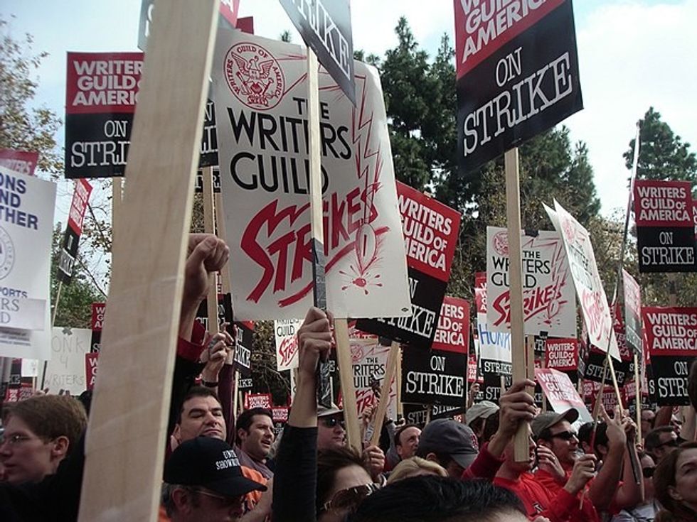 A crowd of people holding strike signs