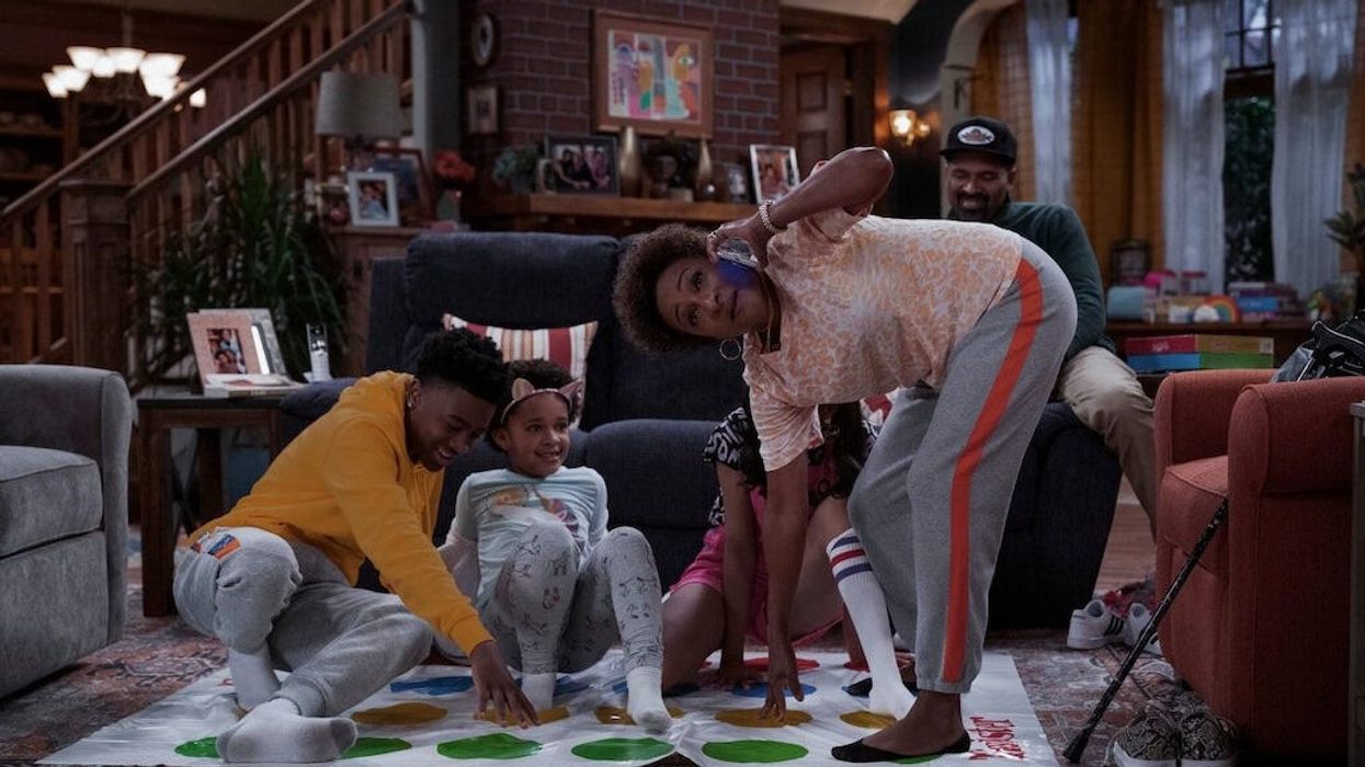 A family playing Twister in a living room in 'The Upshaws'