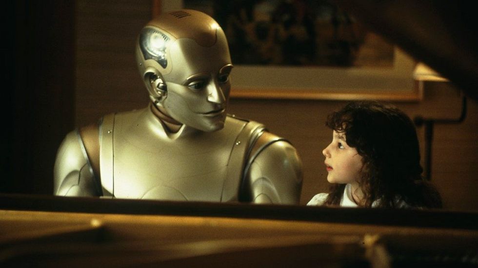 A golden robot sits with a child