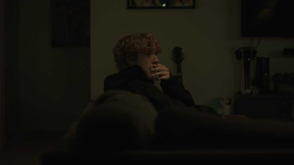 A man sitting on a couch in a living room in This Is Why You Listen
