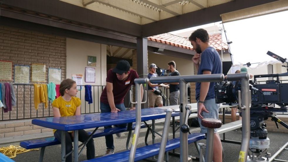A man talking to a child actor about a scene, 'Amelia (the Twin)'