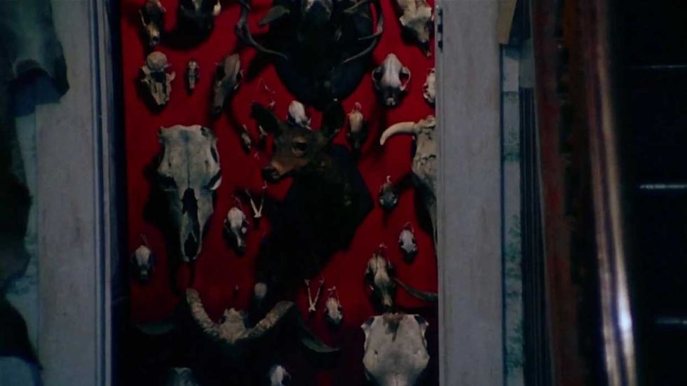 A red wall covered in skulls viewed through a doorway in The Texas Chain Saw Massacre