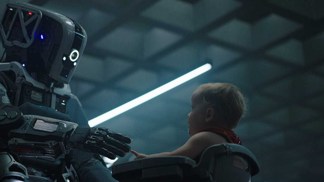 A robot feeding a baby food.