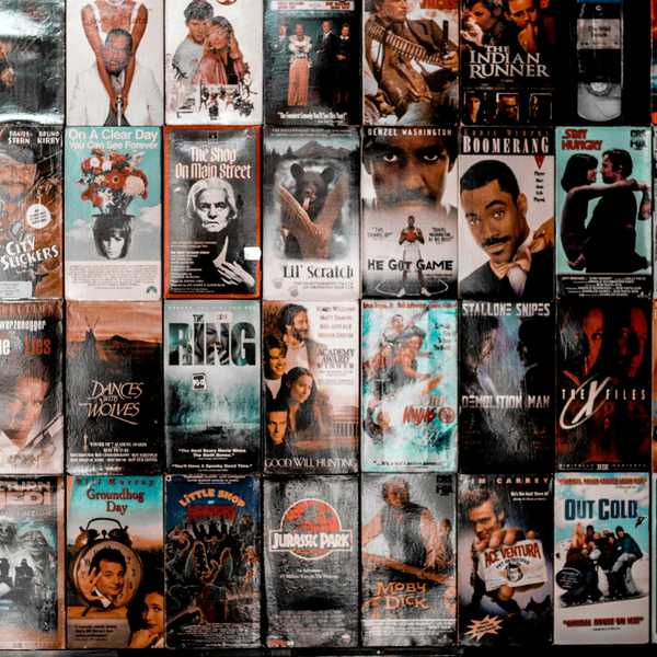 A wall covered with a grid of vintage VHS movie cassette covers