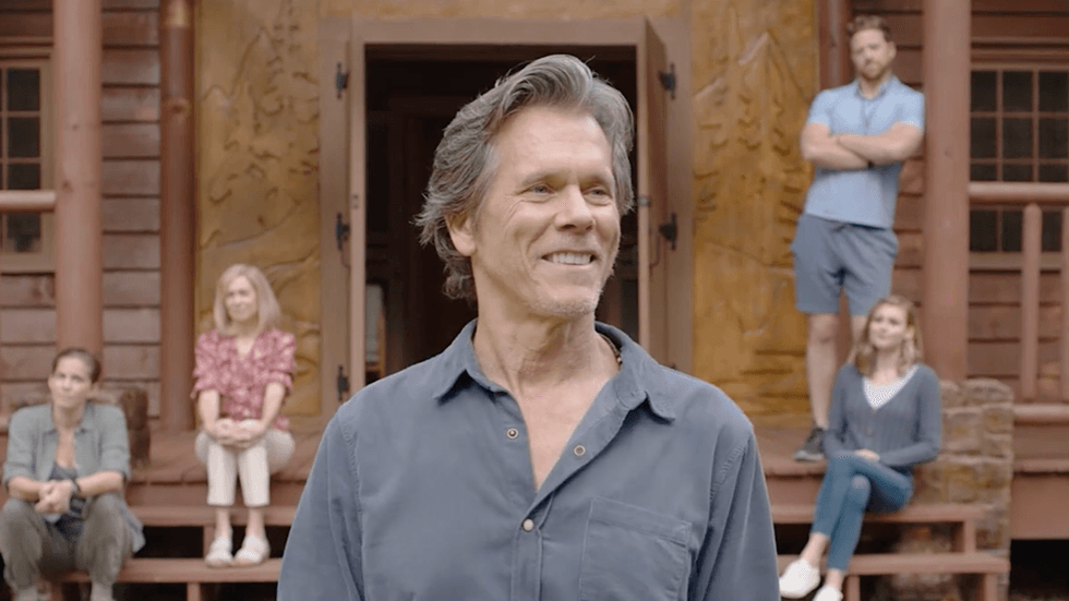 Actor Kevin Bacon as camp director Owen Whistler on the porch of the main lodge in They/Them
