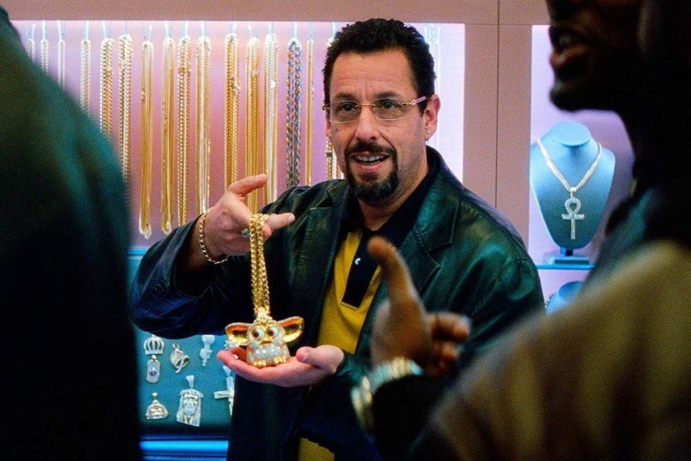 Adam Sandler holding a gold chain in 'Uncut Gems'