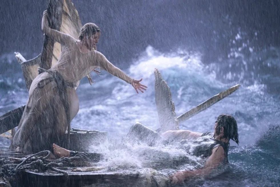 An Elven woman reaching out to a drowing man, 'The Lord of the Rings: The Rings of Power