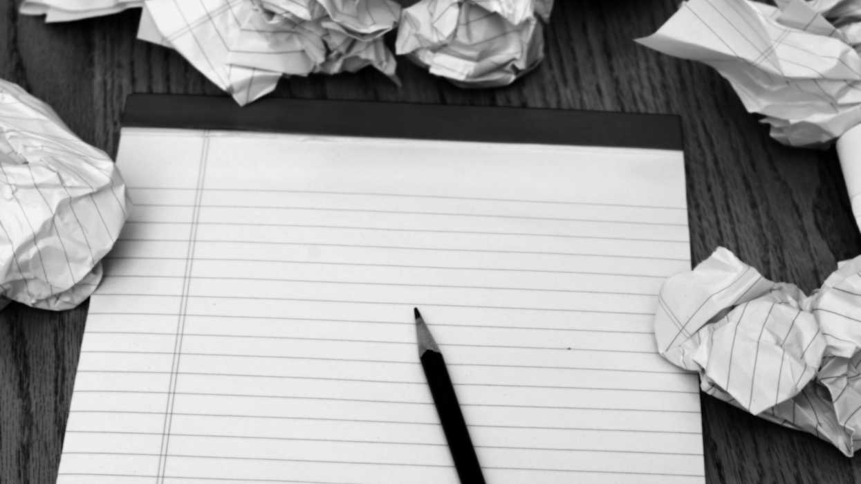 An empty notepad with crumpled pages and a pencil nearby