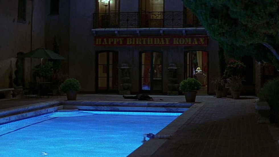 An exterior shot of a body by the pool at the mansion in Scream 3