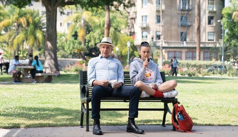 An old man and a teenage girl sitting on a park bench eating ice cream, 'Shrinking'