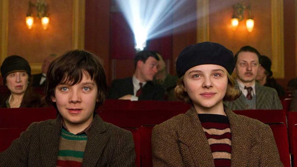 Asa Butterfield and Chloe Grace Moretz sitting together in a movie theater in Hugo