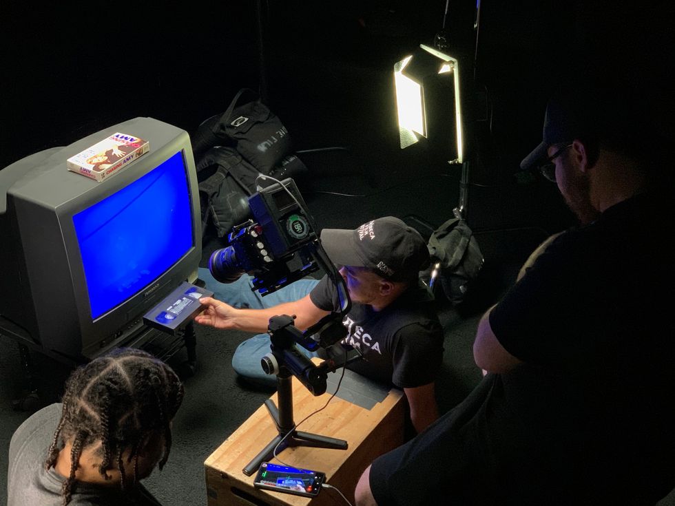 Behind the scenes look at someone entering a VCR into a box TV with a blue screen in 'Chasing Chasing Amy'