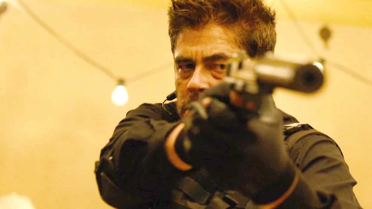 Benicio Del Toro as Alejandro holding a man at gunpoint in Sicario