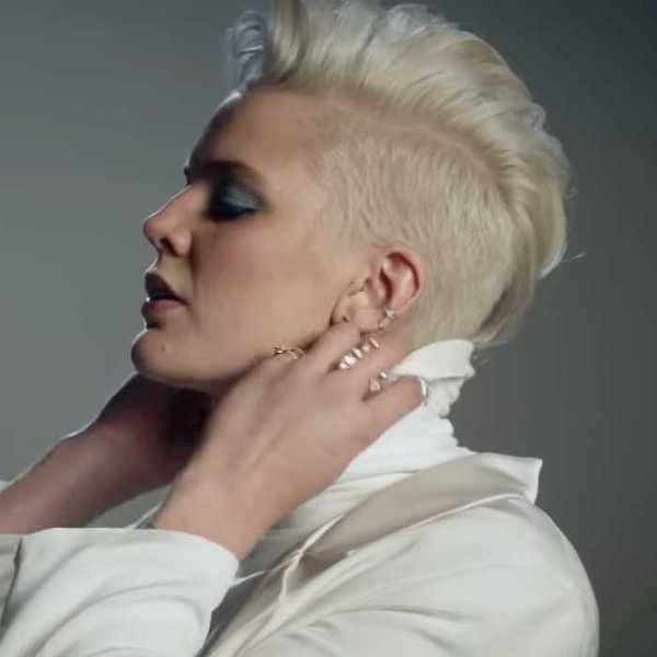 Betty Who adjusting a turtleneck in the Ignore Me music video