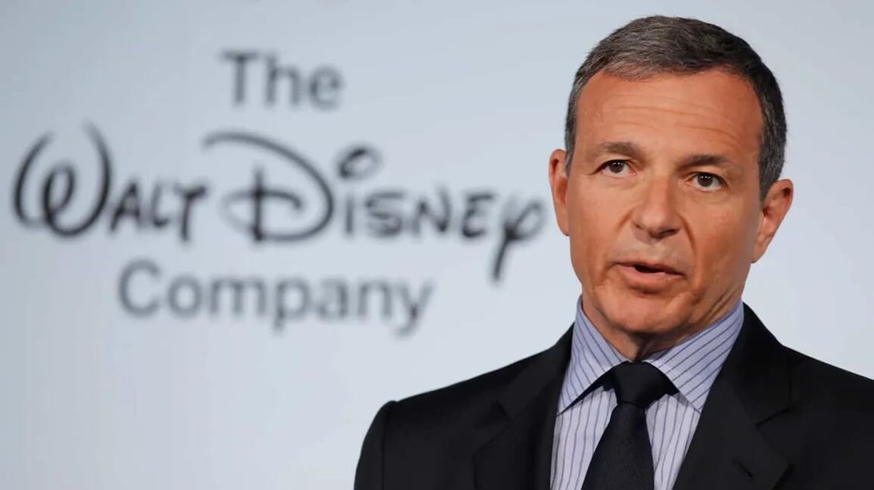 Bob Iger standing in front of a Disney logo