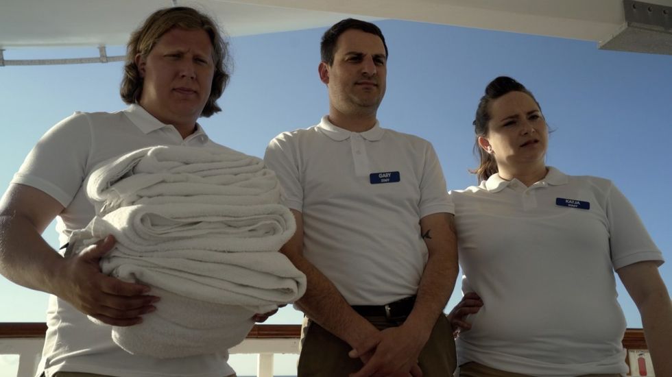 Cast pretending to be staff on secret cruise ship film.