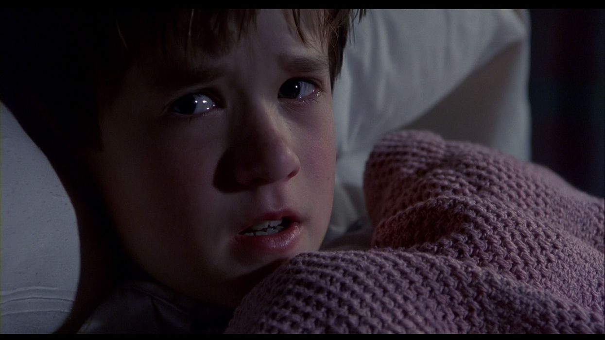 Cole Sear, played by Haley Joel Osment, layng in bed with tears in eyes in 'The Sixth Sense'