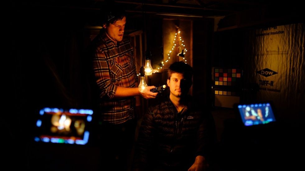 DP Justin Derry takes a light meter reading on set, as Frank Appolonio sits in.