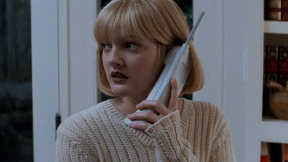 Drew Barrymore as Casey Becker looking nervous while on the phone in Scream 1996
