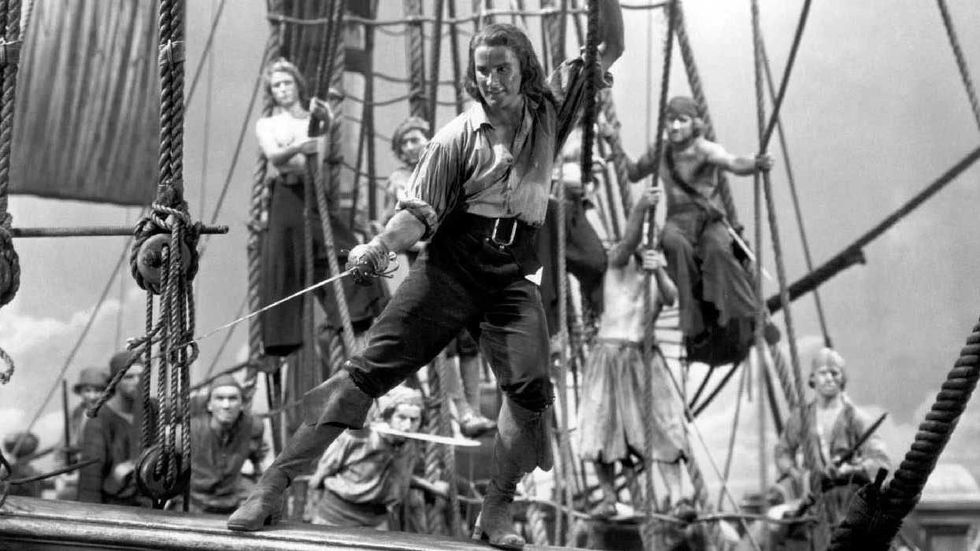 Errol Flynn as Peter Blood holding onto the rigging of his ship in Captain Blood
