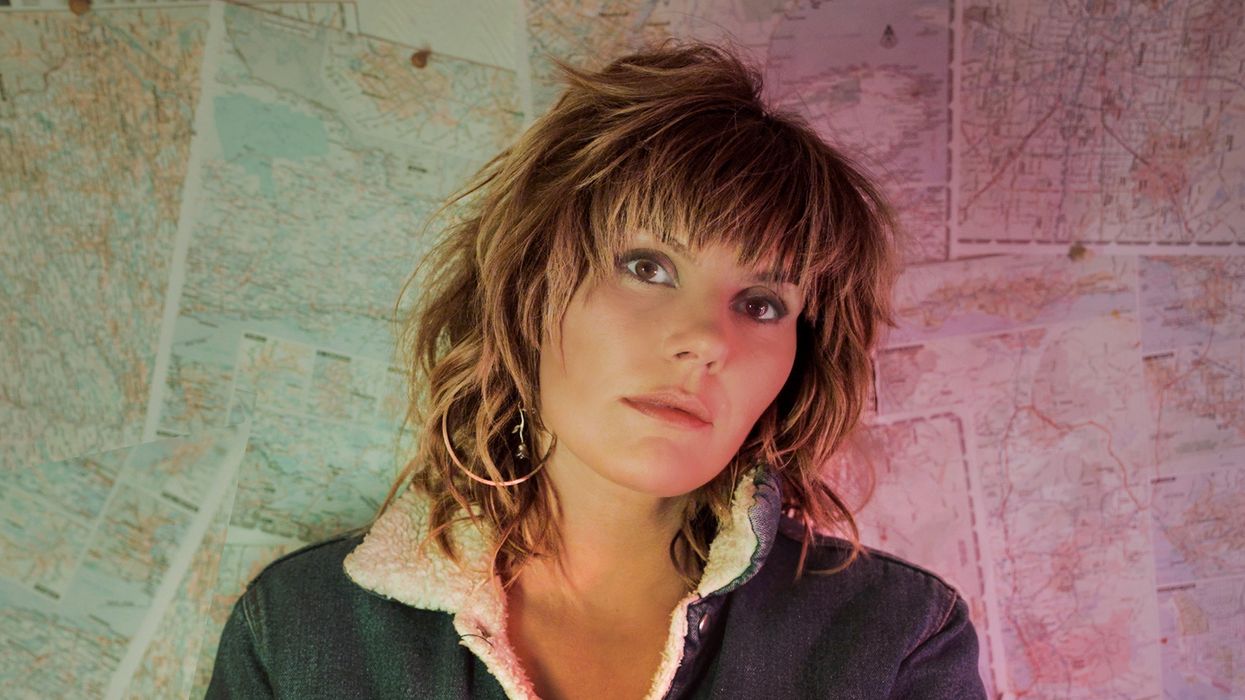 Grace Potter stading in front of a pink and green wall