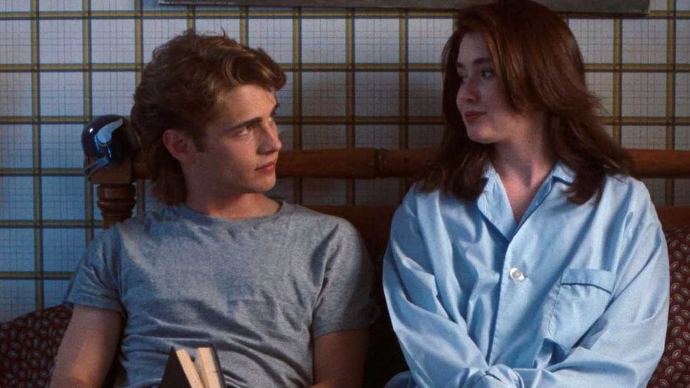Jason Priestley as Brandon and Shannen Doherty as Brenda looking at one another in bed in the Beverly Hills, 90210 pilot