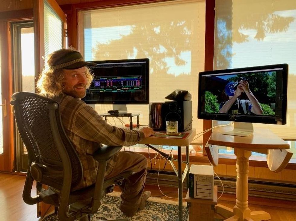 Jason Reid editing 'SAM NOW' on two desktop computers.
