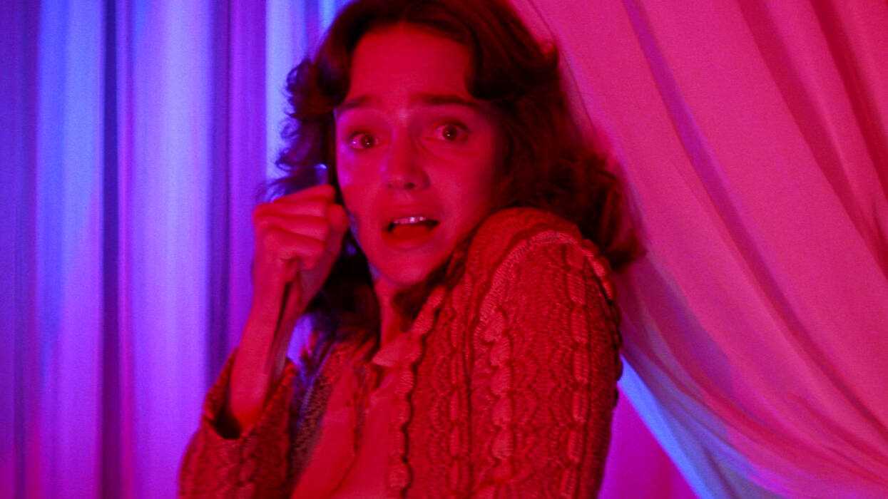 Jessica Harper as Suzy looking scared while holding a knife in Suspiria 1977