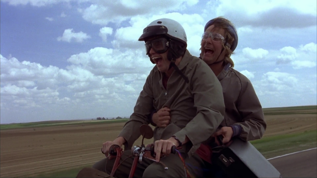 Jim Carrey as Lloyd Christmas and Jeff Daniels as Harry Dunne riding on a motorcycle on the highway in 'Dumb and Dumber'