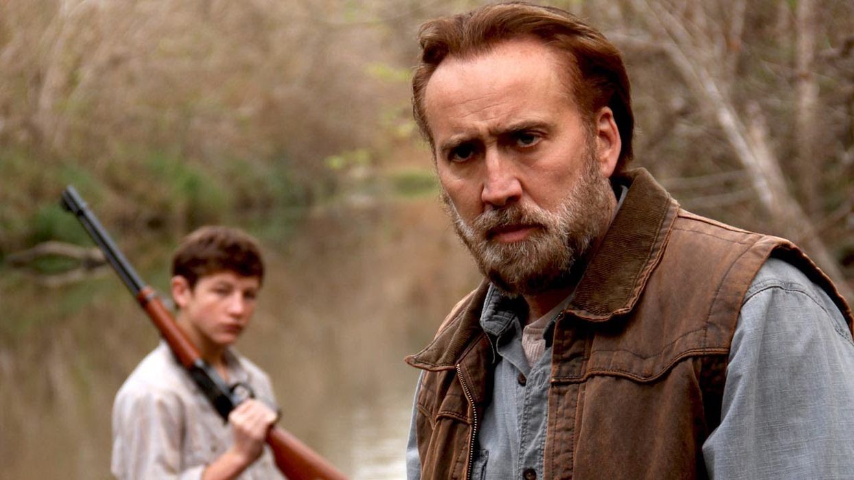  Joe Ransom, played by Nicolas Cage, and Gary Jones, played by Tye Sheridan, on a lake with a rifle in 'Joe'
