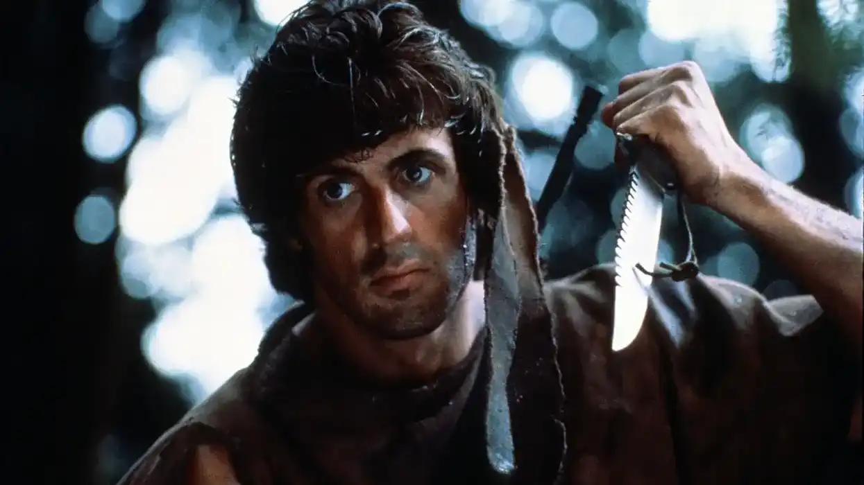 John Rambo (Sylvester Stallone) is holding a knife in First Blood.