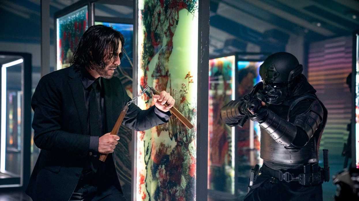 John Wick holding nunchucks fighting a masked man with a gun