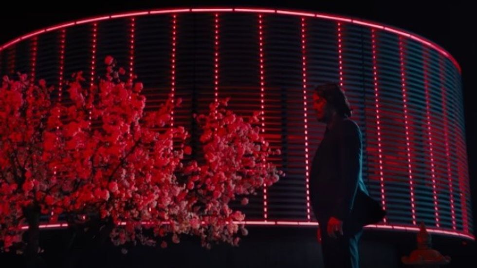 John Wick in Osaka standing against a red background