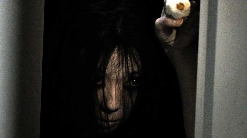 Kayako emerging from the darkness in The Grudge