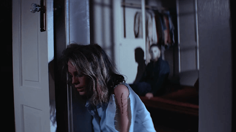 Laurie Strode and Michael Myers in the background in the 1978 horror film Halloween