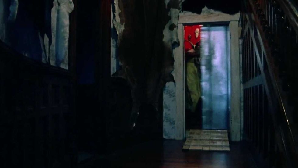 Leatherface shutting a metal sliding door in The Texas Chain Saw Massacre