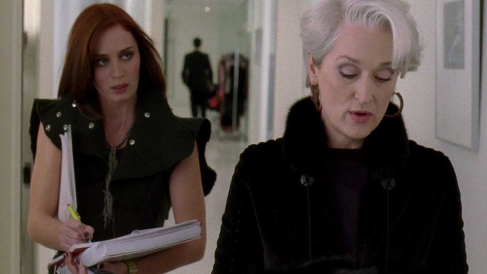 Meryl Streep as Miranda Priestly chatting with Emily Blunt as Emily while walking down the hall in The Devil Wears Prada