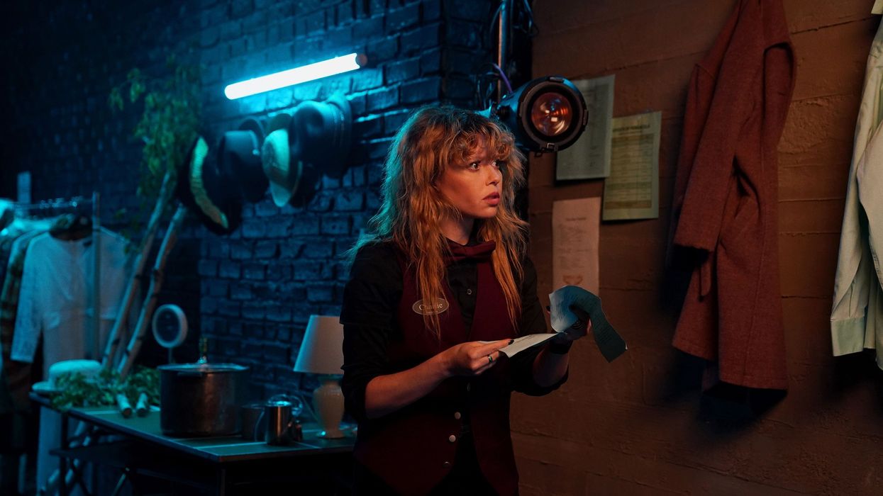 Natasha Lyonne as Charlie Cale in a dark room reading a list in 'Poker Face'