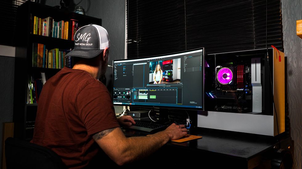 photo of video editor sitting at his workstation.