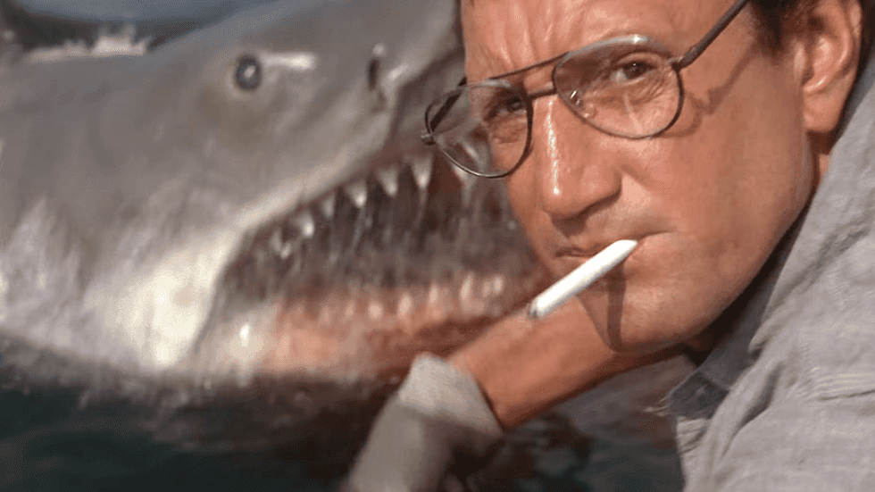 Police Chief Martin Brody smoking a cigarette next to the mechanical shark on the set of Jaws