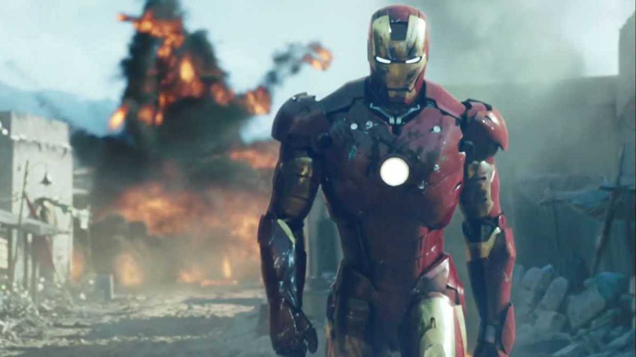 Robert Downey Jr. as Iron Man is walking away from an explosion.