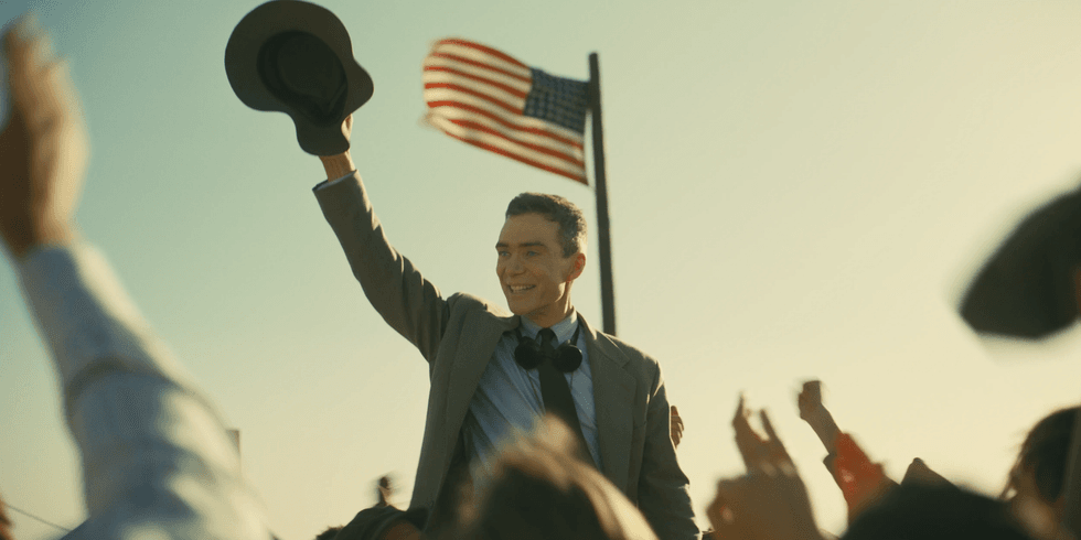 Robert J. Oppneheimer, played by Cillian Murphy, celebrating under the American flag.
