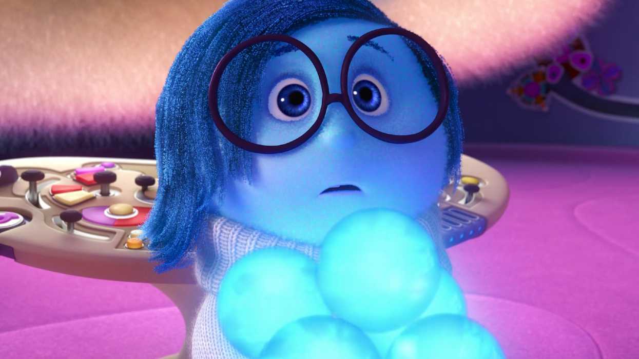 Sadness holding an armful of blue memories in Inside Out