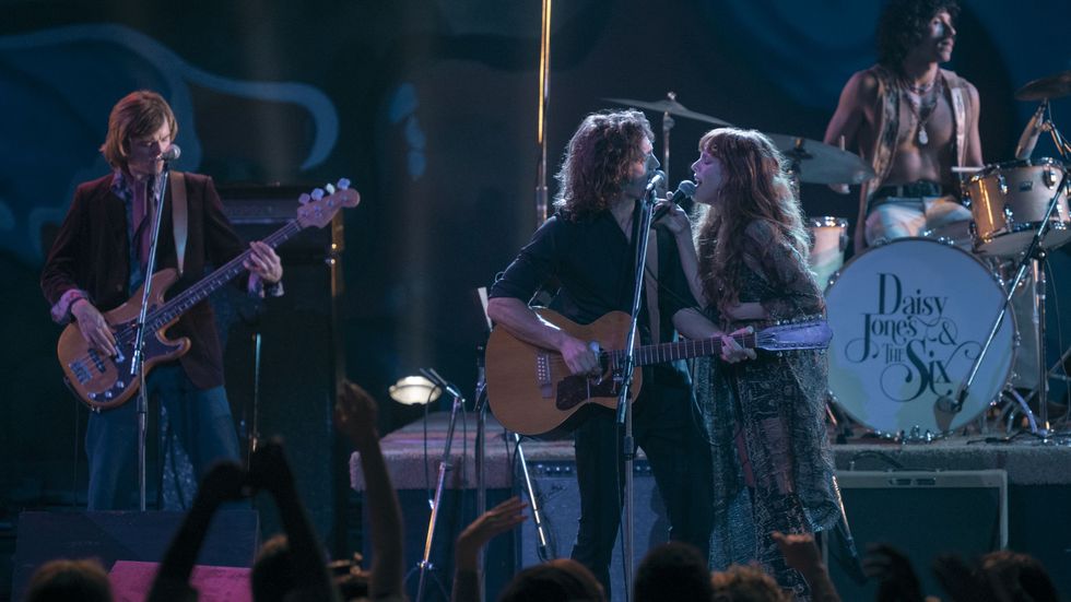 The band singing on stage in 'Daisy Jones & the Six'