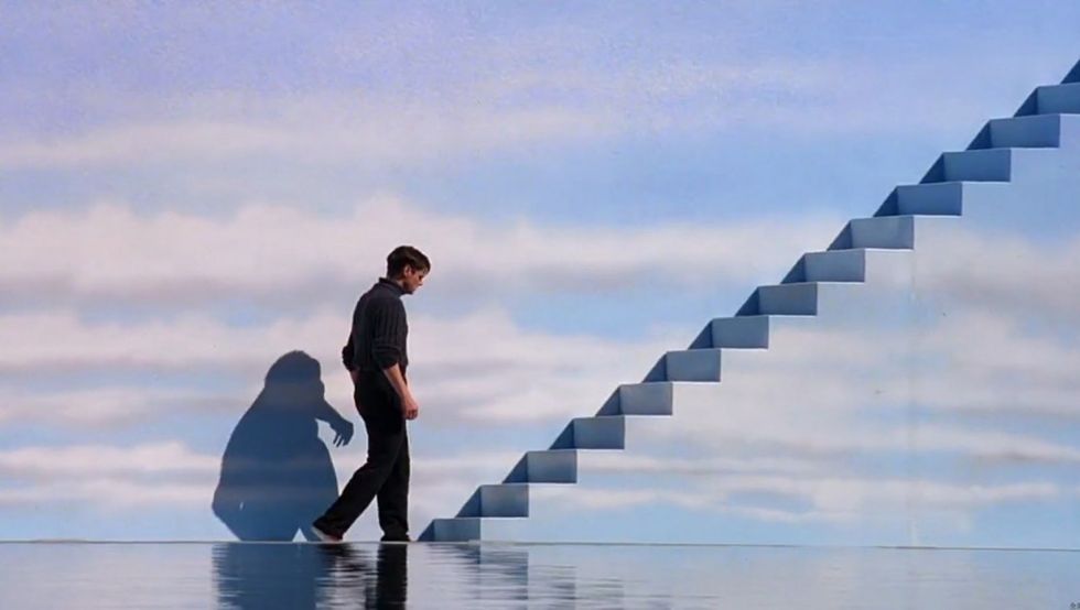 Truman Burbank, played by Jim Carrey, walking up a cloud painted staircase in 'The Truman Show'