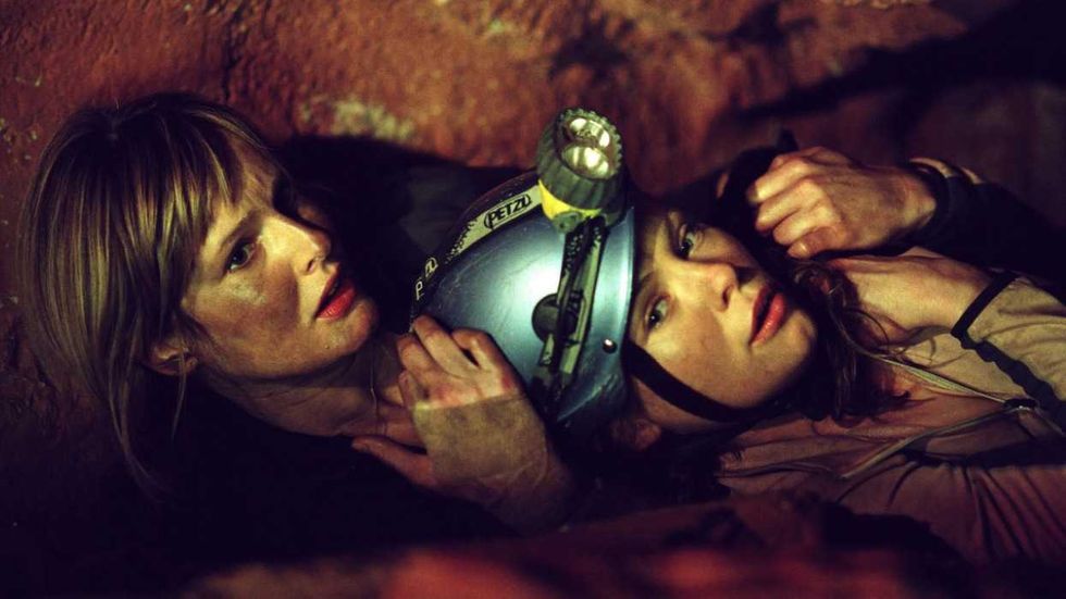 Two characters navigating a tight tunnel in The Descent