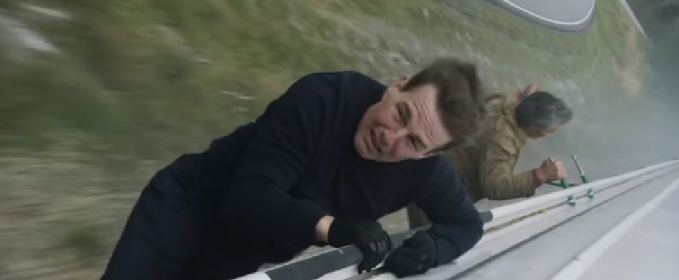 Two men hanging onto the side of train, 'Mission: Impossible -- Dead Reckoning Part One'